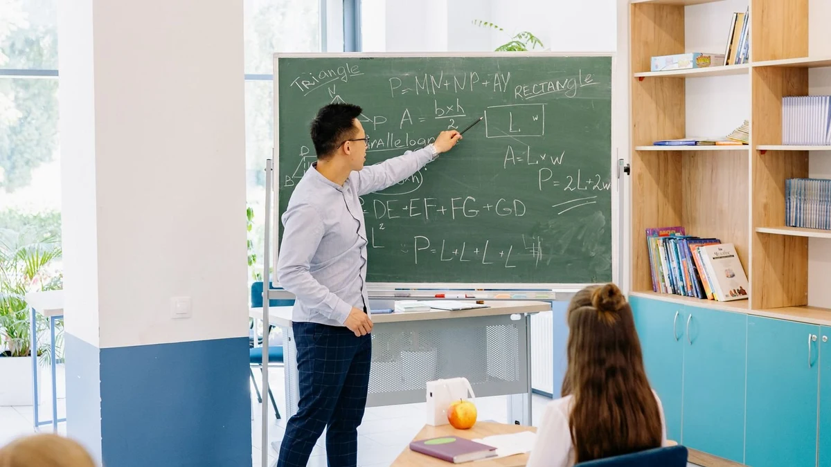 Teacher explaining a lesson on a blackboard in a classroom
